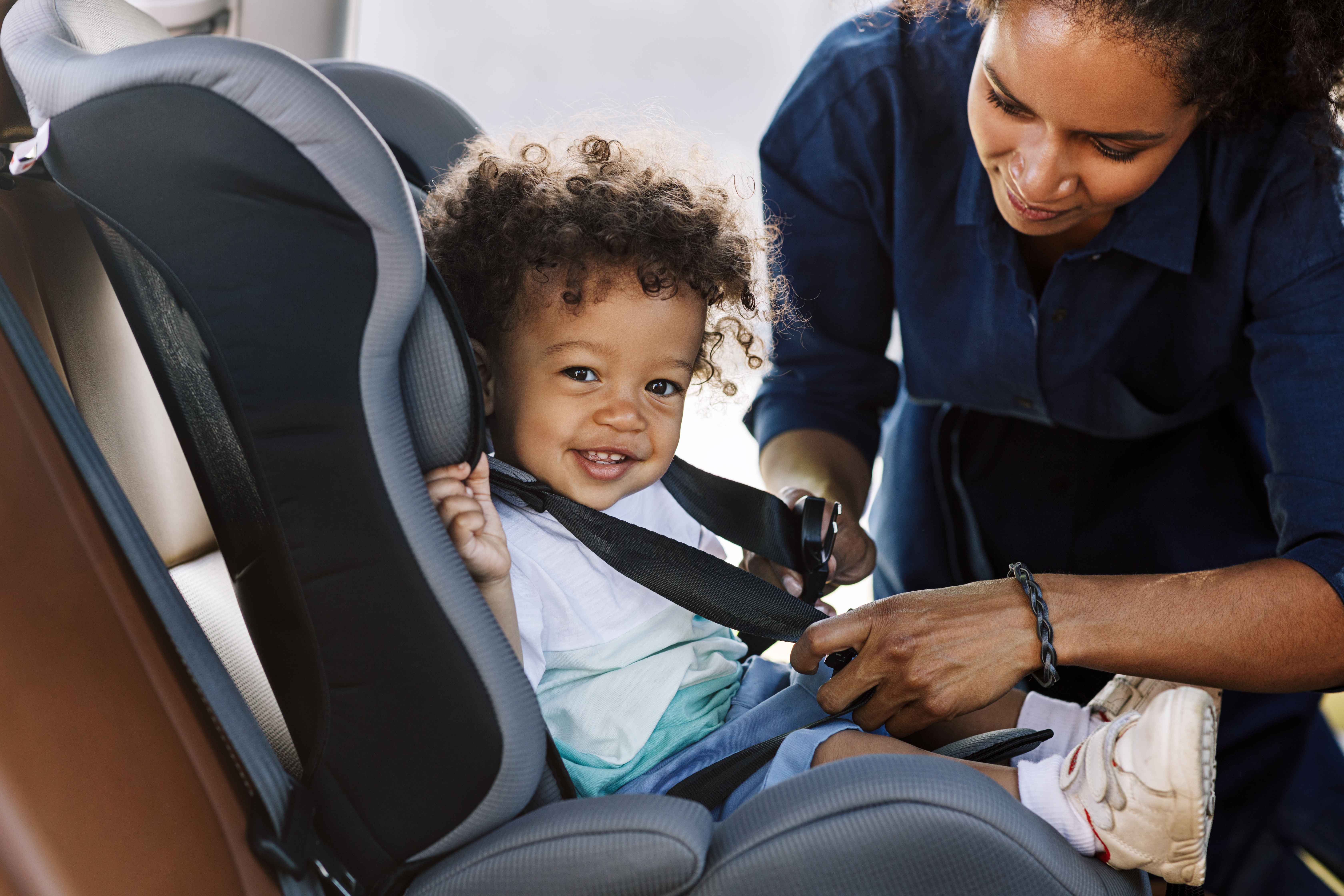 Child being fastened in car seat