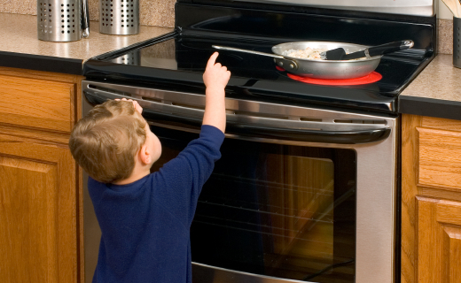 child reaching up at stove