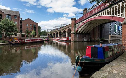 a canal and barge positioned under a bridge