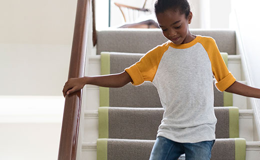 Woman running upstairs after small child in the home