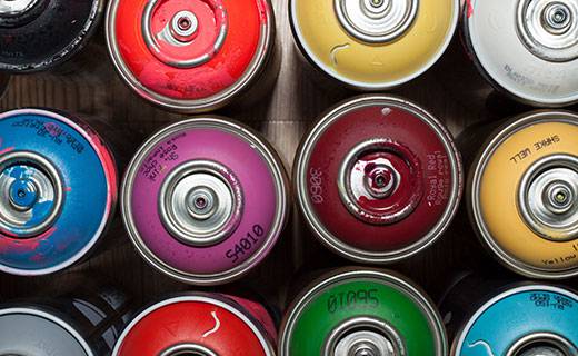 multi-coloured aerosol cans seen from the top