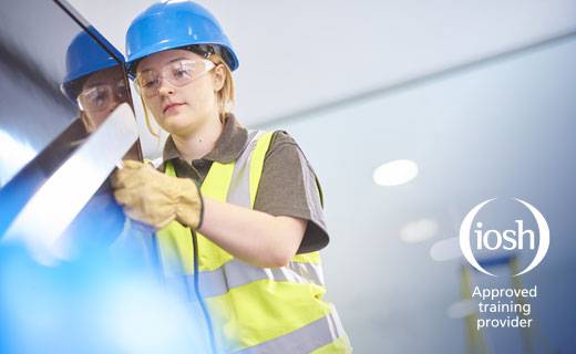 Woman in safety equipment operating machinery