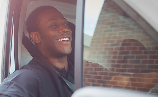 Man looking happy whilst driving a van for work