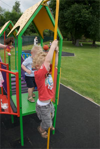 A picture of a child hanging from play equipment.