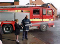 A student attempts to use a fire hose
